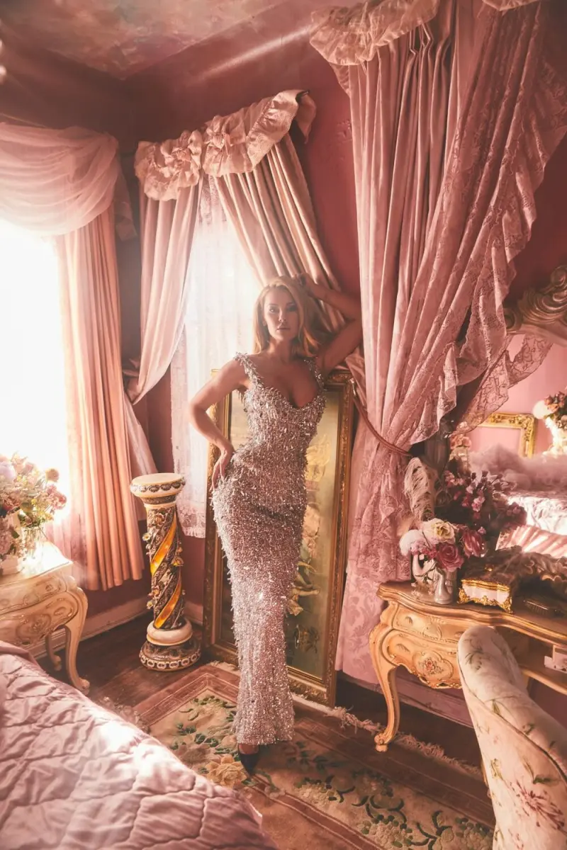 Katherine Taylor standing in a silver sequined gown in a pink bedroom